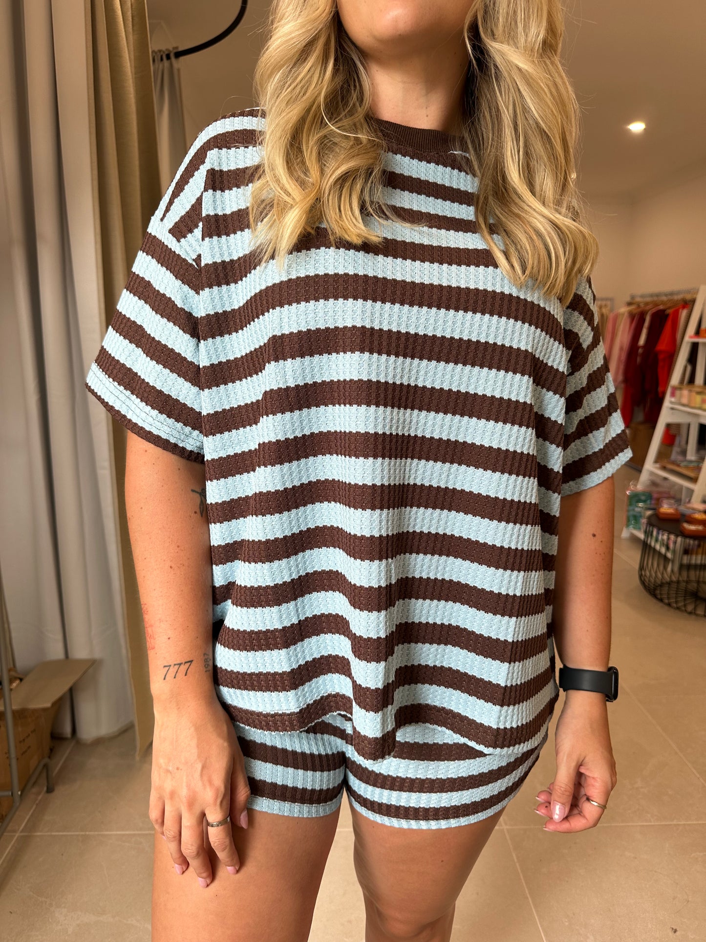 Person wearing a brown and blue striped outfit in an indoor setting