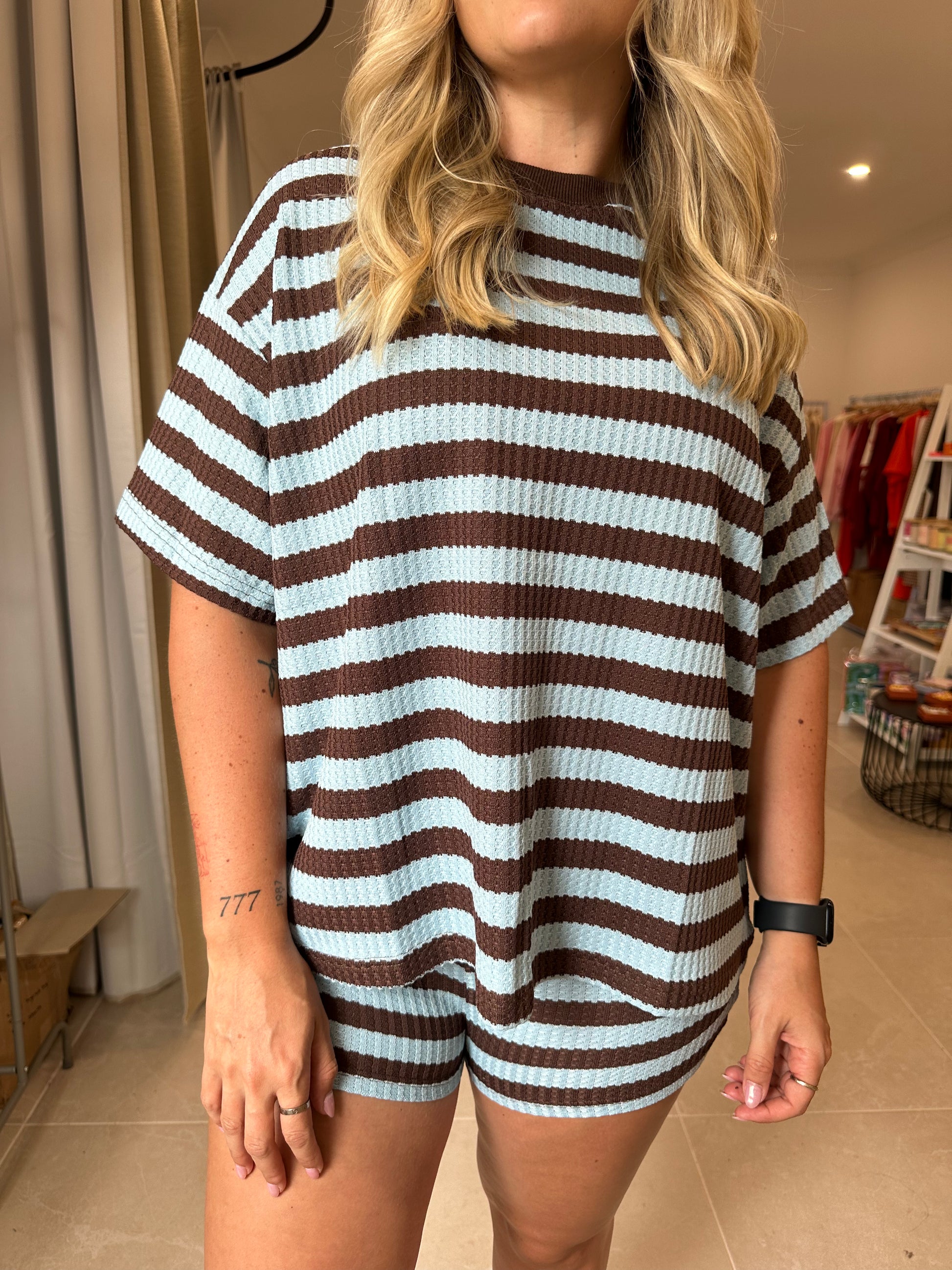 Person wearing a brown and blue striped outfit in an indoor setting